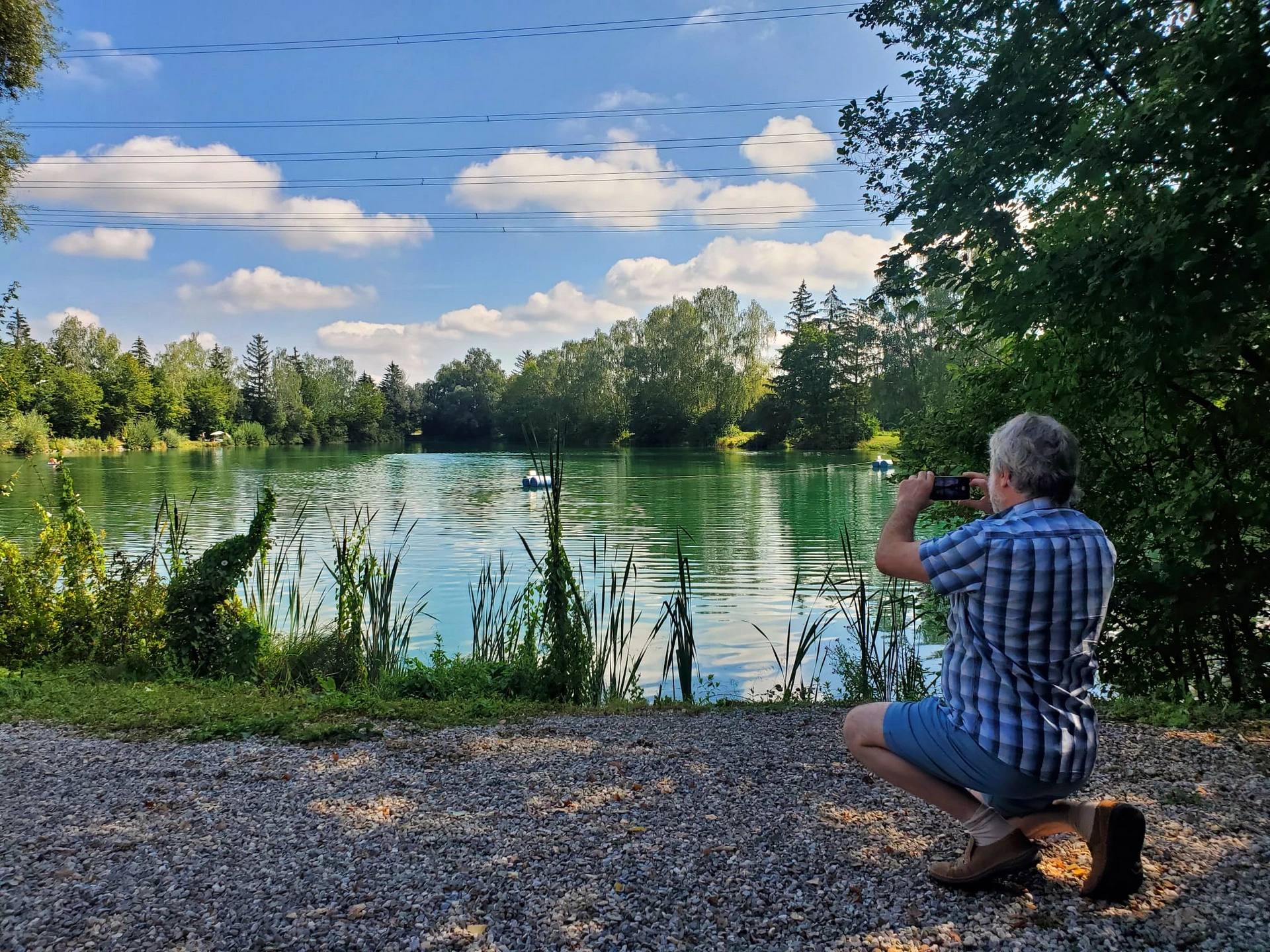 Der Autor in knieender Haltung beim Fotografieren des See-Panoramas