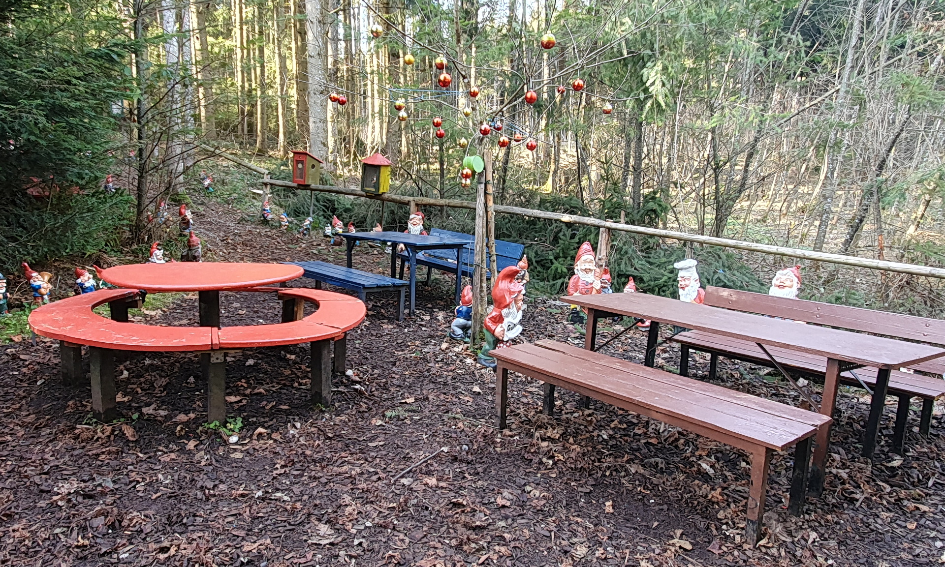 Der Picknickplatz mit bunten Tischen und Bänken.